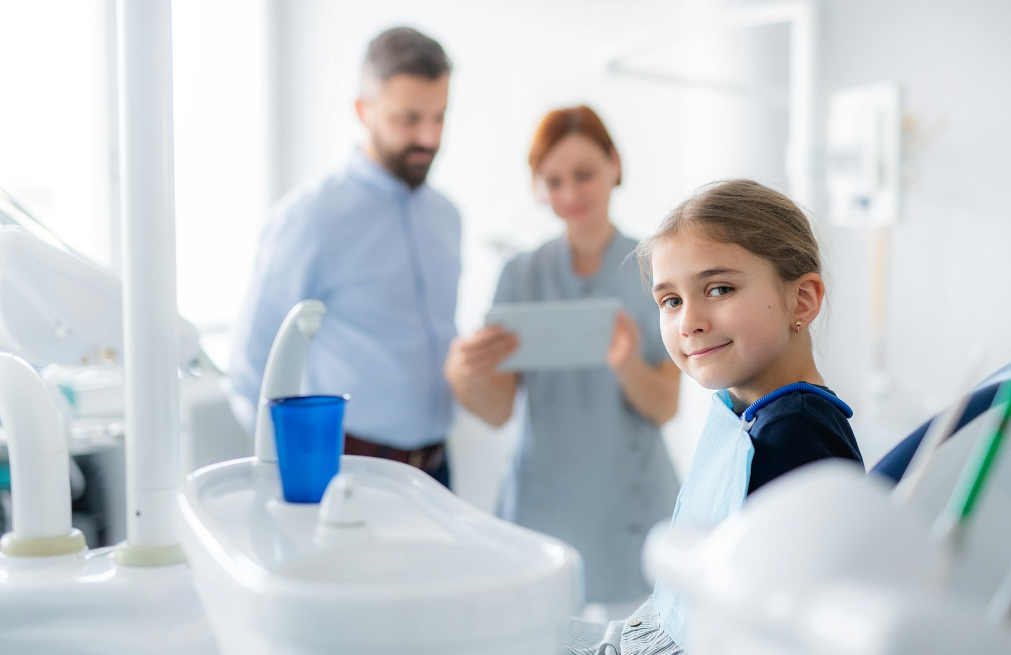 Annual dental check-up of a child with father in dentist surgery