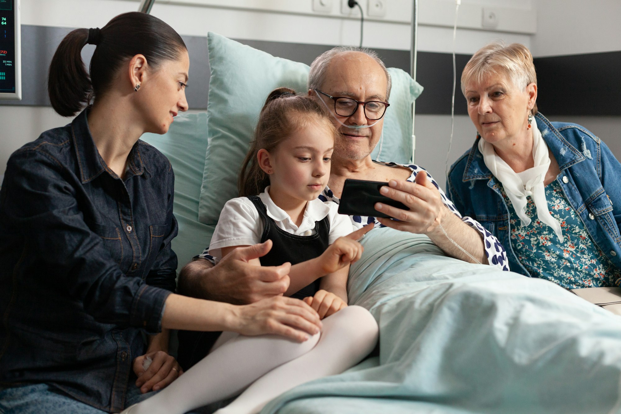 Cheerful family visiting elderly grandfather in hospital ward during clinical recovery