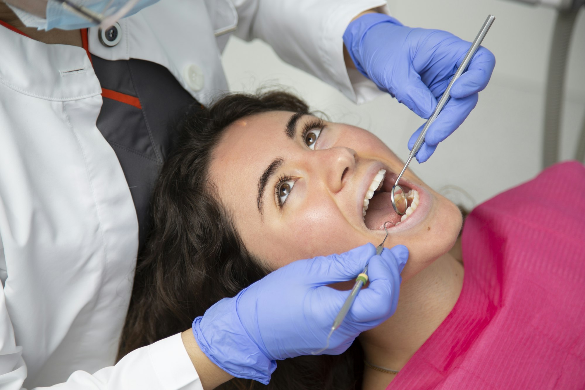 Closeup of dentist working on a girl's mouth.