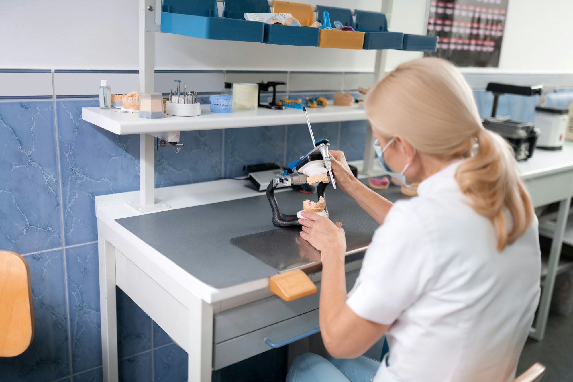 Dental technician constructing prosthetic denture for the patient