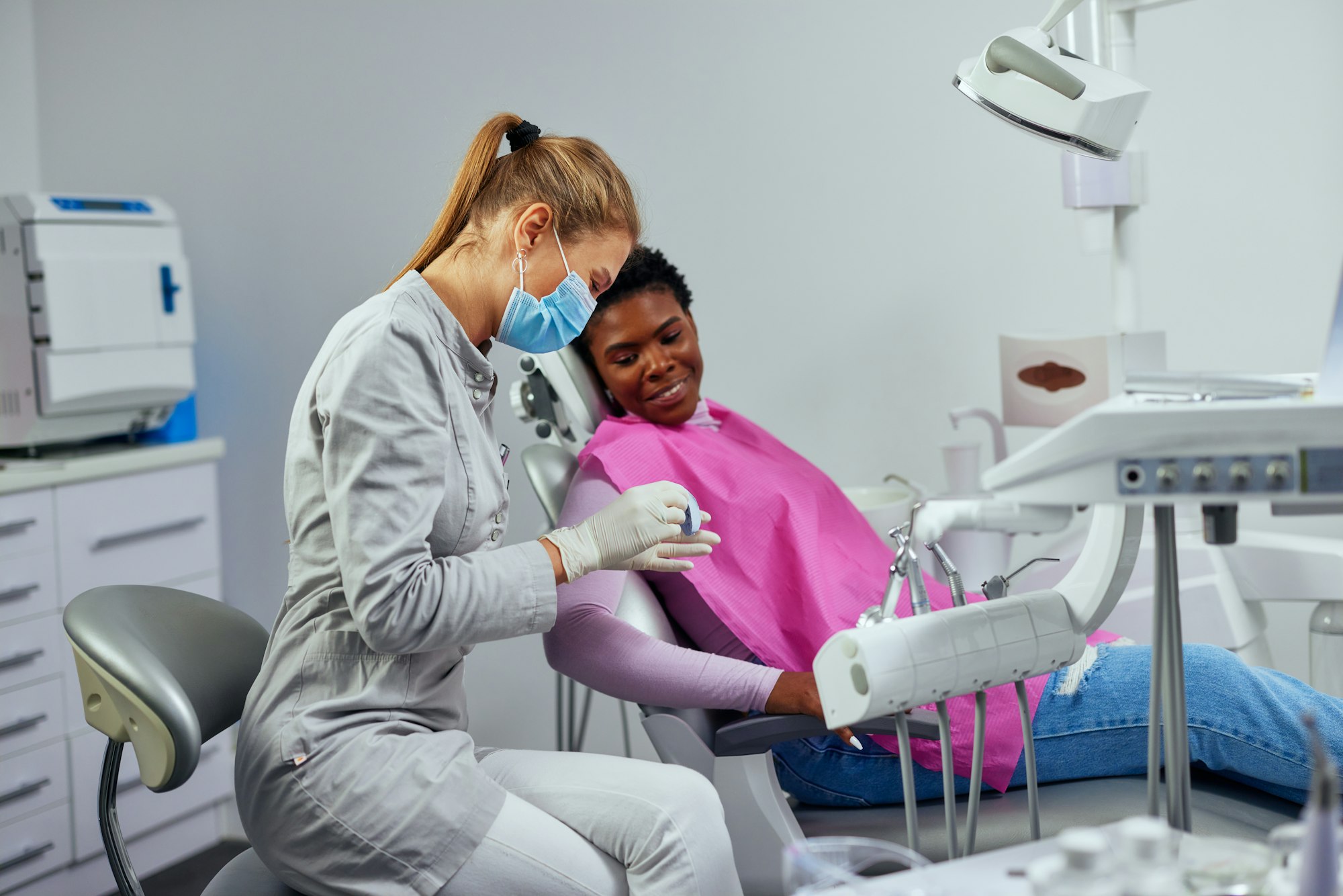 Dentist showing denture to african patient