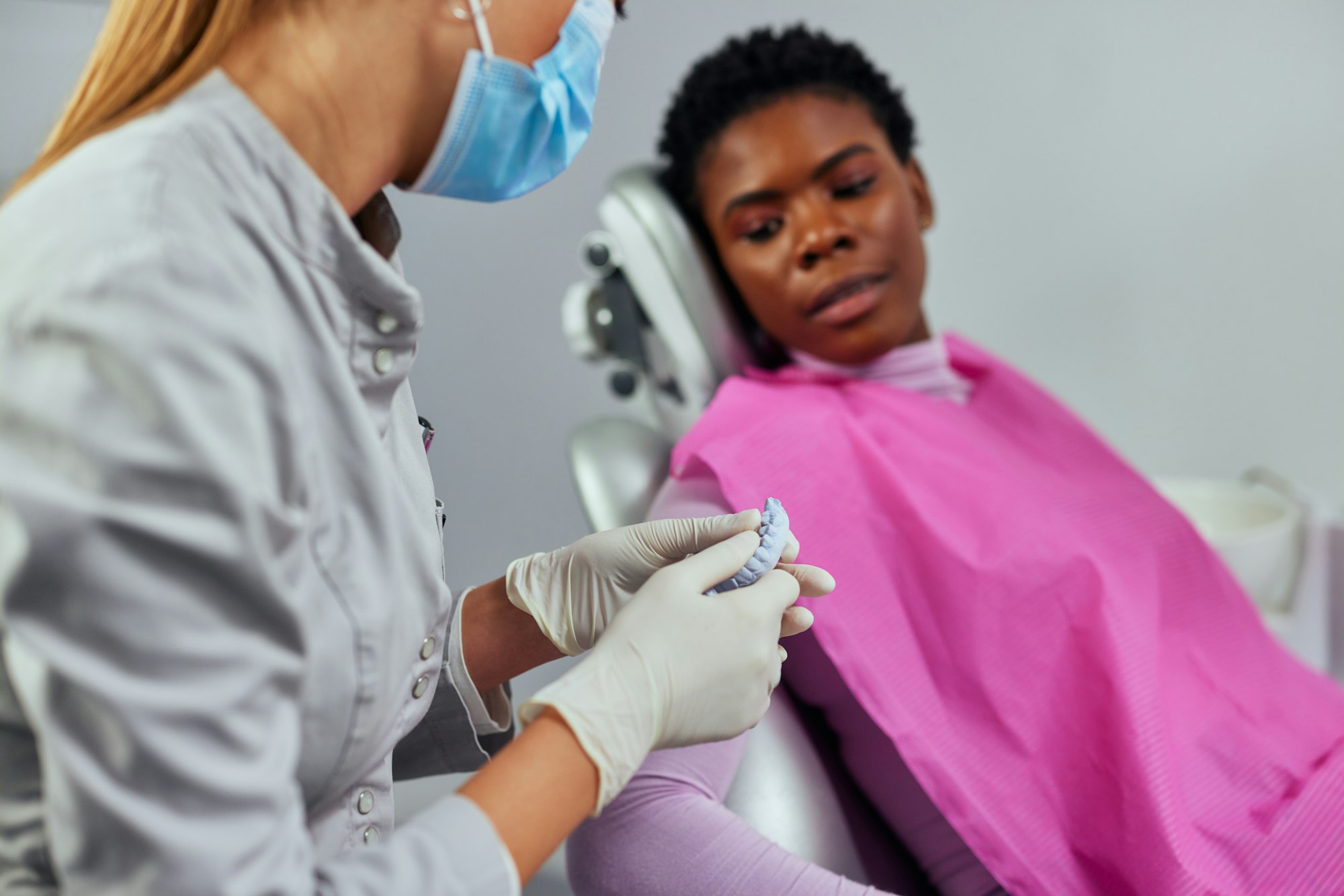 Dentist showing teeth dentures to a patient