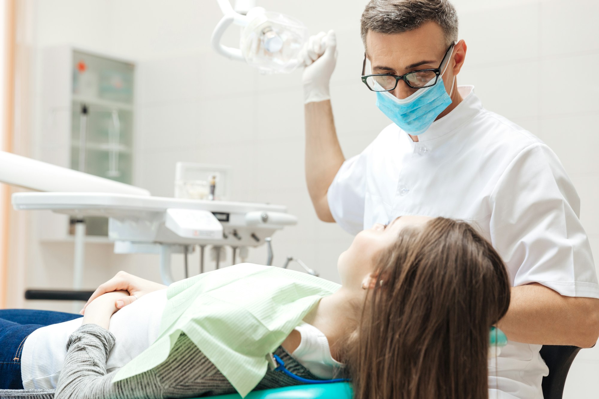 Dentist very carefully check up and repair tooth to patient