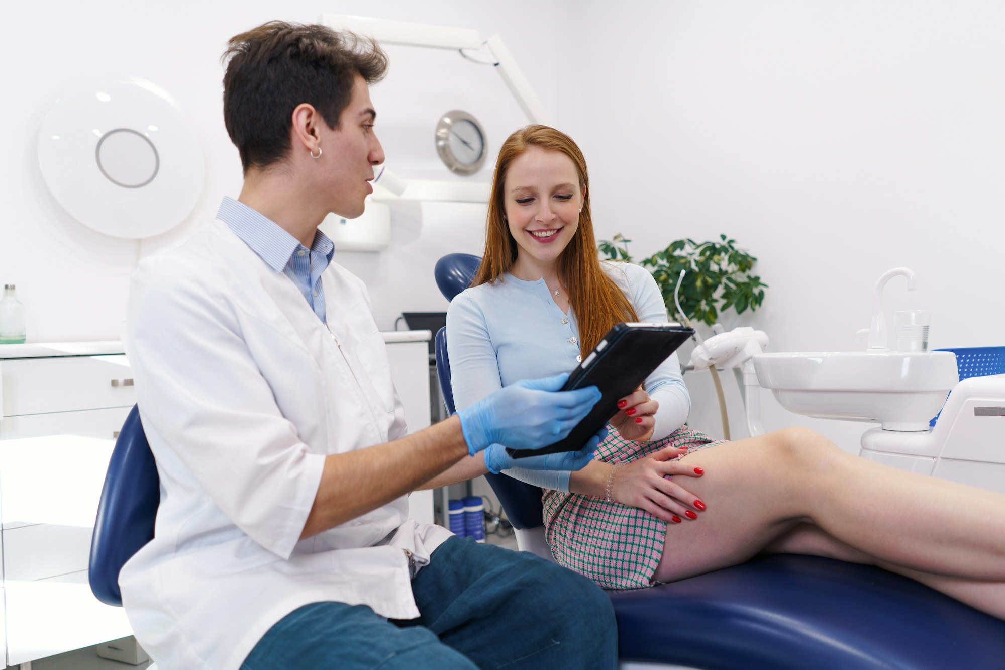 Dentist showing treatment options to happy woman