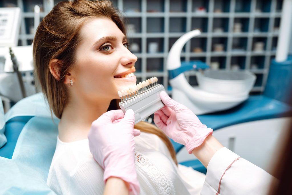 Young woman at the dentist's chair during a dental procedure. Overview of dental caries prevention.